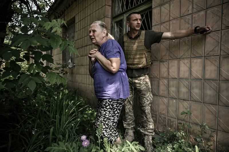 An elderly woman reacts as Ukrainian soldiers lead her to safety during a battle with Russian troops in Lysychansk. AFP