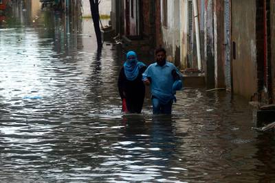 Residents wades through a flooded street after heavy monsoon rains in Pakistan's port city of Karachi.  AFP