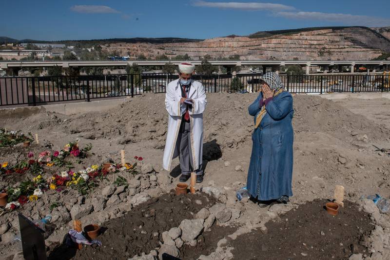 A woman prays near the graves of the two members of Dogruya family who died after a powerful earthquake. Getty Images
