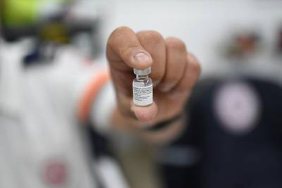 A paramedic from Israel’s Magen David Adom emergency services holds a vial of the Pfizer-BioNTech vaccine.