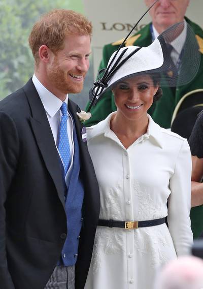 Britain's Prince Harry, Duke of Sussex, (L) and Britain's Meghan, Duchess of Sussex react after presenting the trophy for the St James's Palace Stakes race on day one of the Royal Ascot horse racing meet, in Ascot, west of London, on June 19, 2018. - The five-day meeting is one of the highlights of the horse racing calendar. Horse racing has been held at the famous Berkshire course since 1711 and tradition is a hallmark of the meeting. Top hats and tails remain compulsory in parts of the course while a daily procession of horse-drawn carriages brings the Queen to the course. (Photo by Daniel LEAL-OLIVAS / AFP)