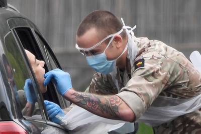 A member of the military tests a person at a coronavirus test centre in the car park of Chessington World of Adventures, Chessington, Britain, London, Britain.  Reuters