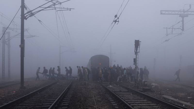 People cross railway tracks in heavy fog in a wintry New Delhi. Reuters