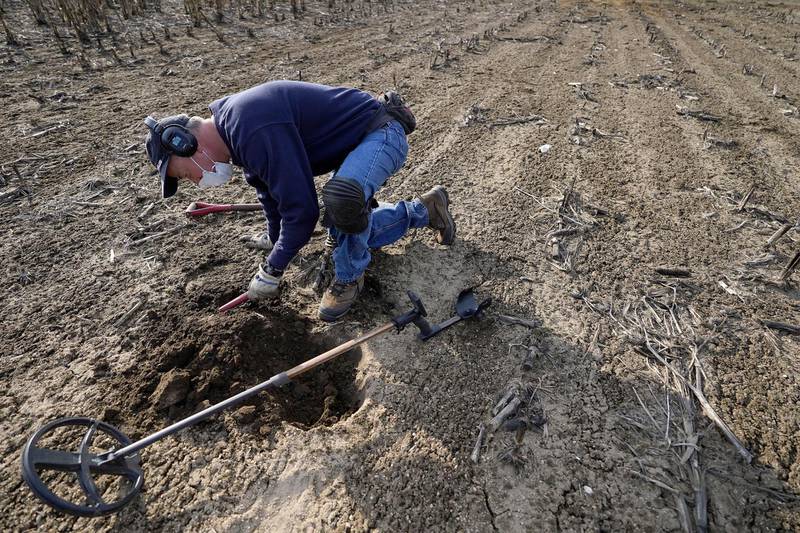 Metal detectorist Jim Bailey scans dirt for Colonial-era artifacts in a field, Thursday, March 11, 2021, in Warwick, R.I. Bailey, who holds a degree in anthropology from the University of Rhode Island, found a 17th-century Arabian silver coin in 2014 at a farm, in Middletown, R.I., that he contends was plundered in 1695 by English pirate Henry Every from Muslim pilgrims sailing home to India after a pilgrimage to Mecca. (AP Photo/Steven Senne)