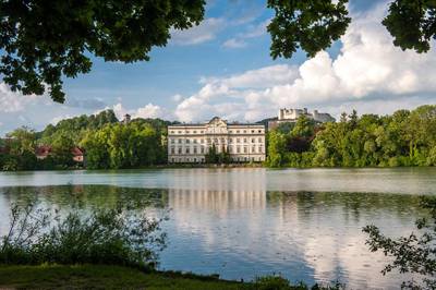 Leopoldskron Palace where the Von Trapp family lived in Sound of Music. In the background is Fortress Hohensalzburg. The city made famous by The Sound Of Music is now host to a new kind of refugees fleeing a dictator. Tourismus Salzburg



