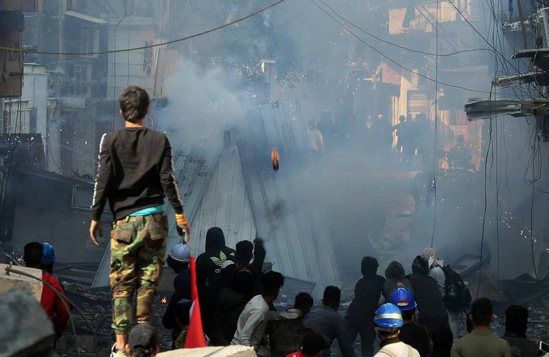Riot police fire tear gas during clashes with anti-government demonstrators in Baghdad. AP Photo