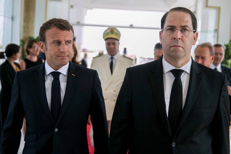 Tunisian Prime Minister Youssef Chahed, right, welcomes French President Emmanuel Macron, upon his arrival at Tunis Carthage airport in Tunis, Tunisia, Saturday, July 27, 2019.  International dignitaries are among those who will attend Saturdayâ€™s funeral ceremony for the countryâ€™s first democratically elected president Beji Caid Essebsi, who died in office at 92.(AP Photo/Hassene Dridi)