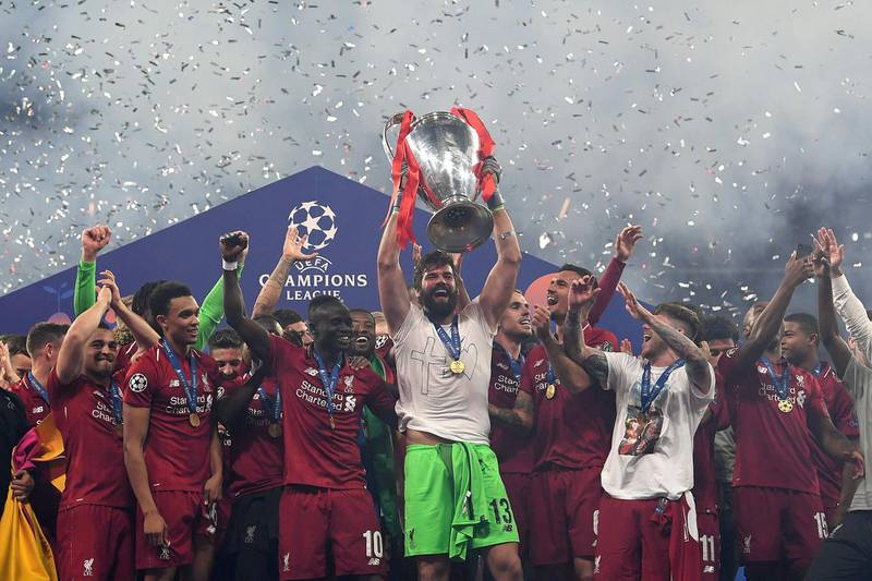 Alisson lifts the European Cup surrounded by his teammates. AFP