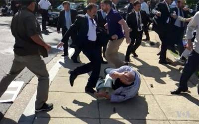 FILE- In this file frame grab from video provided by Voice of America, members of Turkish President Recep Tayyip Erdogan's security detail are shown violently reacting to peaceful protesters during Erdogan's trip last month to Washington. A grand jury in the U.S. capital announced Tuesday, Aug. 29, 2017, that it issued indictments for 19 people, including 15 identified as Turkish security officials, for attacking protesters in May 2017. (Voice of America via AP, File)
