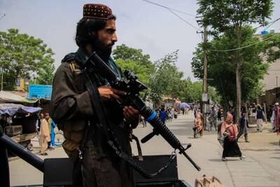 A Taliban fighter stands guard near the school in the Dasht e Barchi area of west Kabul. EPA