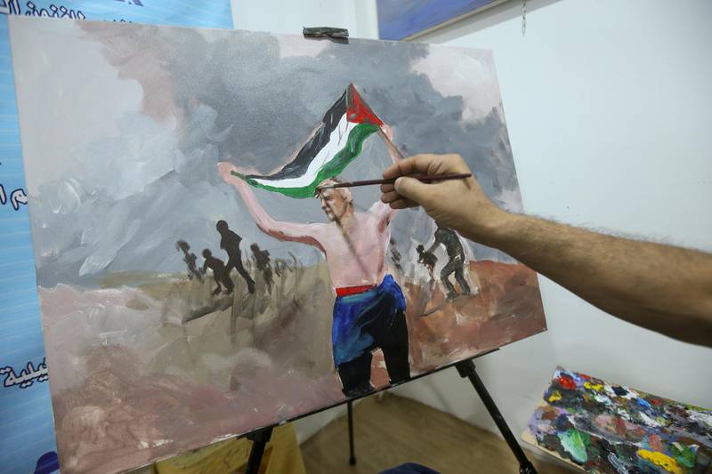 An Iraqi artist paints a pro-Palestinian artwork to express solidarity with the Palestinian people at an art studio in Basra, Iraq. Reuters