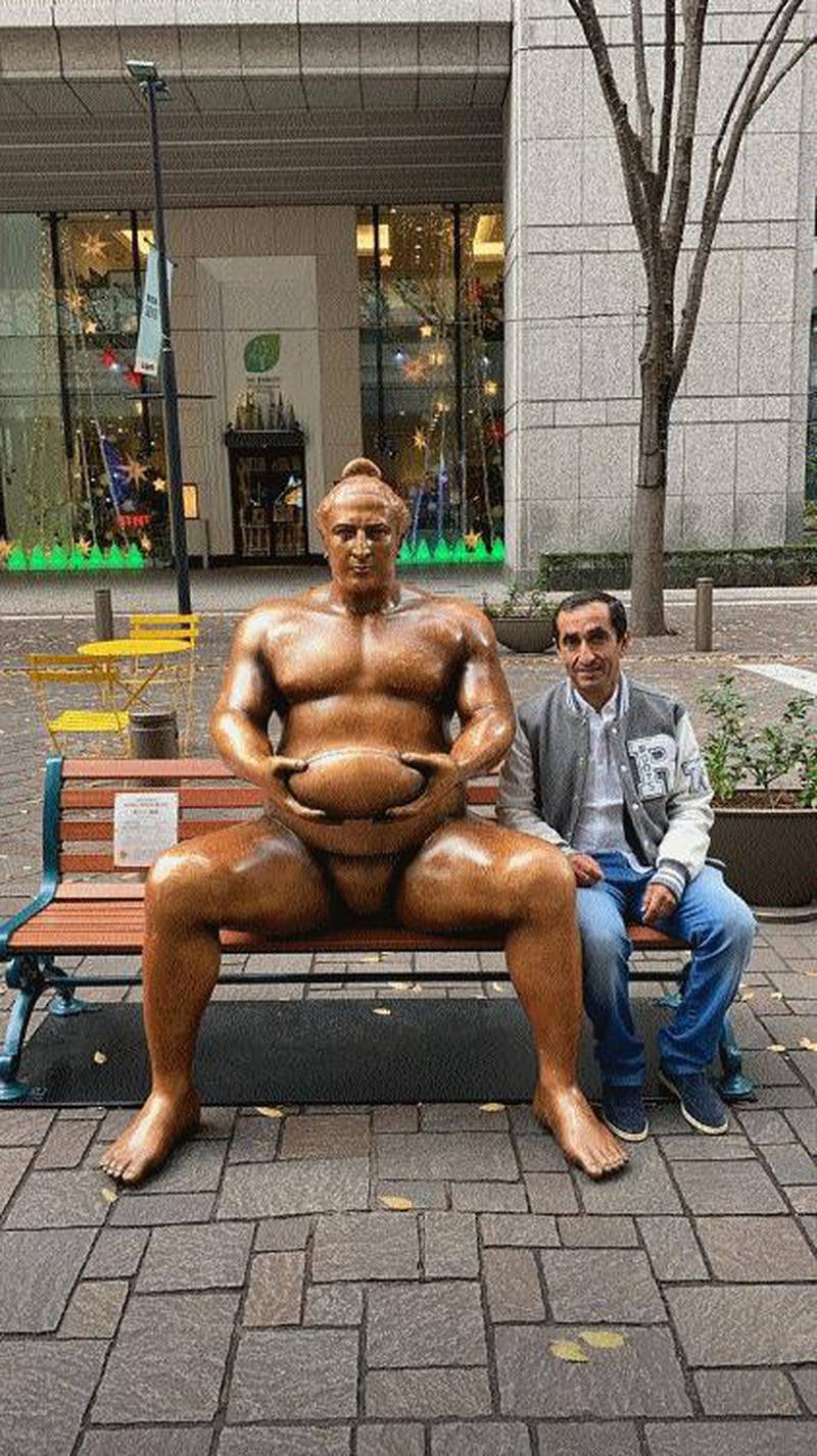 Uncle Saeed poses beside the statue of the Georgian sumo wrestler Tochinoshin Tsuyoshi (Levan Gorgadze) in central Tokyo. Instagram / faz3