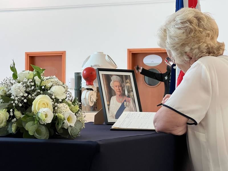 A mourner signs the book of condolences. 