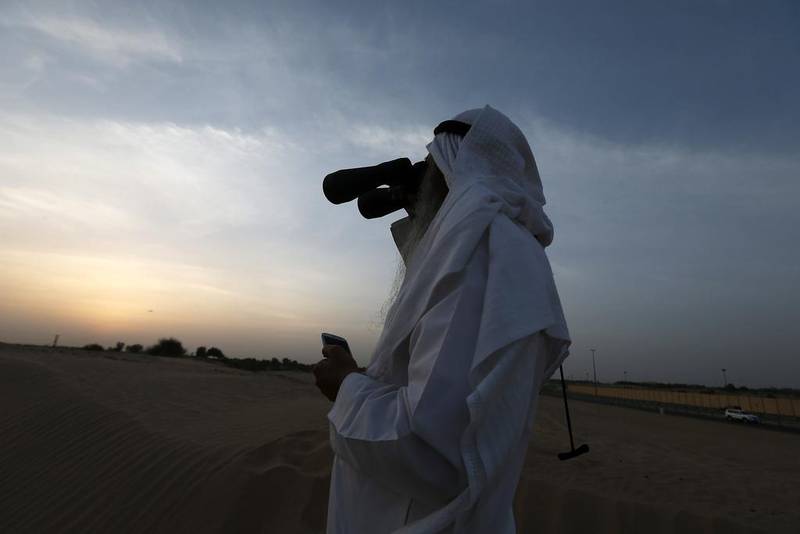 A man looks for the new crescent moon to indicate the start of a new Islamic month. Pawan Singh / The National