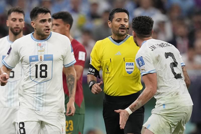 Uruguay's Jose Gimenez, right, argues with referee Alireza Faghani after a penalty was awarded against him for hand ball. AP