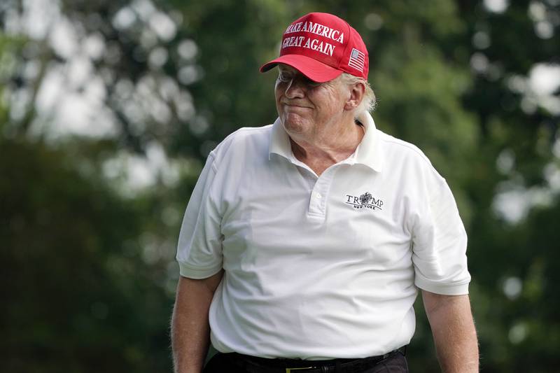 Mr Trump reacts to his tee shot on the fourth hole. AP