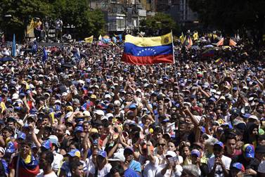 Demonstrators wave Venezuelan flags while listening to Juan Guaido, president of the National Assembly. Bloomberg