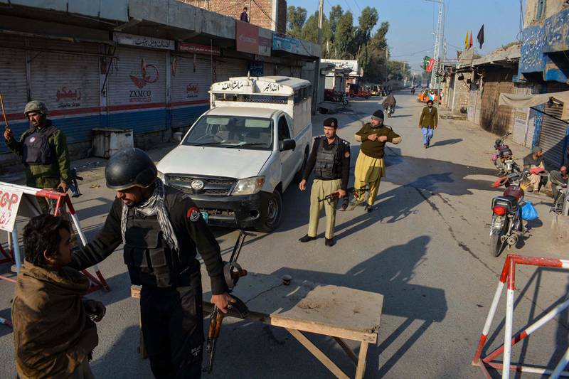 Officers stand guard along a road they blocked after Taliban militants seized a police station in Bannu. AFP
