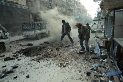 Syrian men check the damage following Syrian government shelling on the town of Douma in the rebel-held enclave of Eastern Ghouta on the eastern outskirts of the capital Damascus on March 10, 2018. Hamza Al-Ajweh / AFP