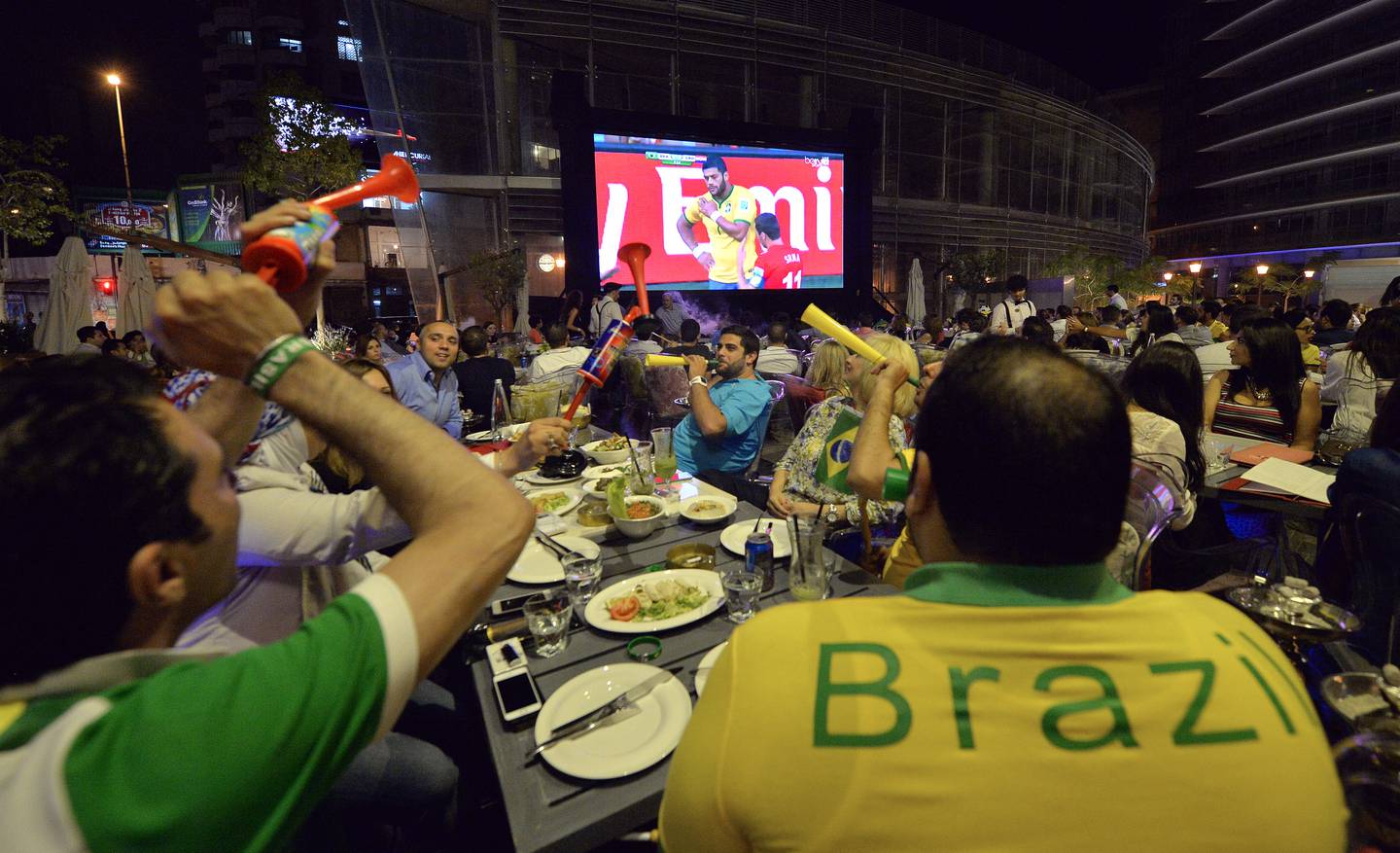 Lebanese soccer fans watch on a big screen the opening match between Brazil and Croatia at the 2014 FIFA World Cup at a cafe in Beirut, 2014. EPA