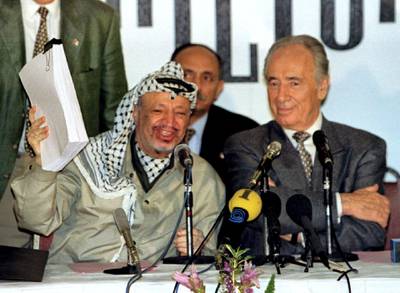 PLO chairman Yasser Arafat holds the second phase of the Oslo peace accords after the initialling of the document, September 24, as Israeli Foreign Minister Shimon Peres looks on. Israel and the PLO will officially sign the agreement in Washington later this week.
**POOR QUALITY DOCUMENT
