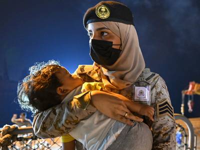 A member of the Saudi Royal Navy carries a child who was rescued from Sudan, in Jeddah. Reuters