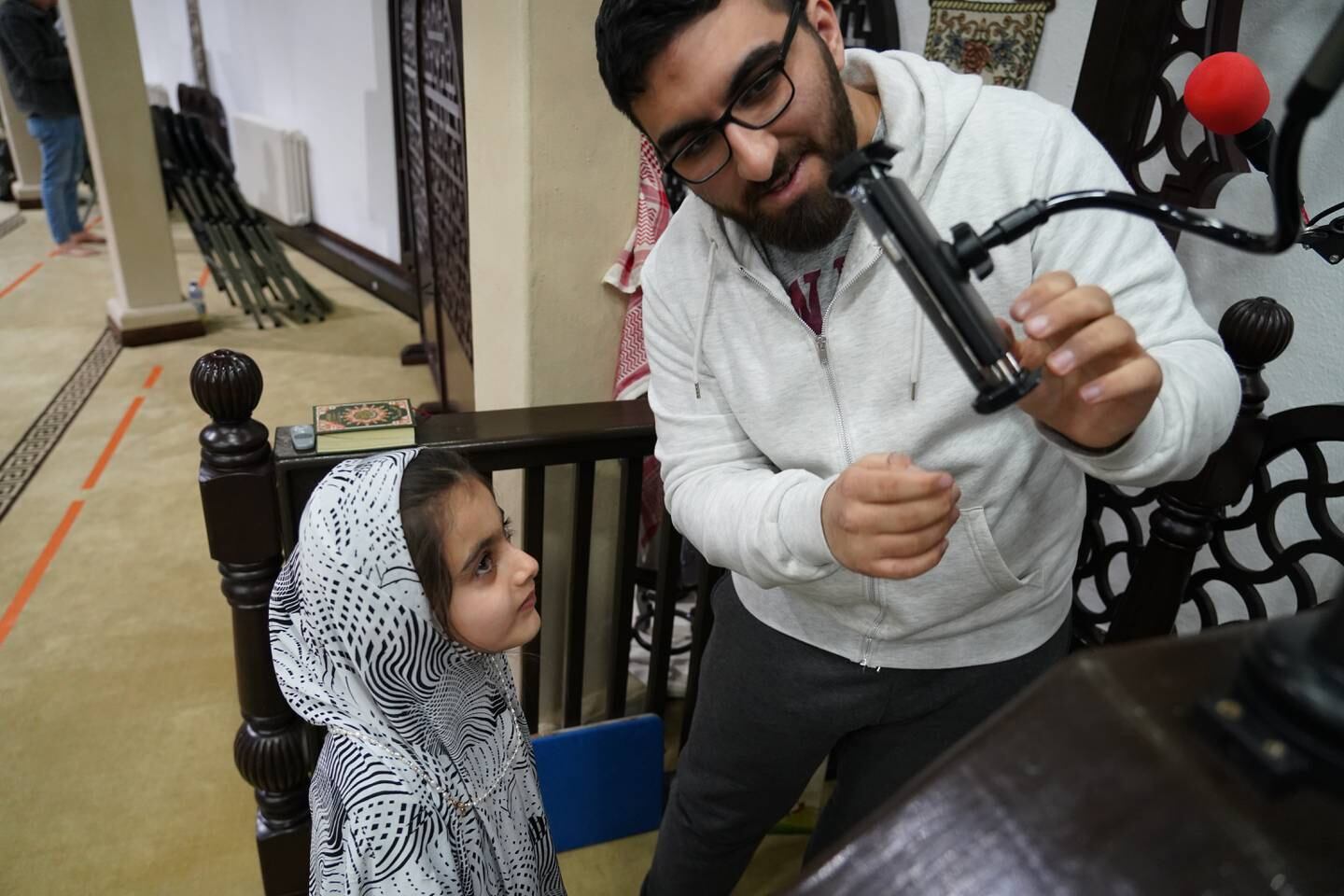 Ali Taha, a volunteer at Al Emaan mosque and Omar's brother, sets up a livestream for the sunset Adhan. During Ramadan 2022, raising the call to prayer at Iftar time rotates between children of the Muslim community. Victoria Pertusa / The National