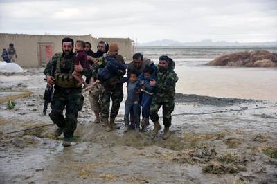 Afghan security forces carry children after flood affected their homes in Arghandab district of Kandahar province, on March 2, 2019. AFP