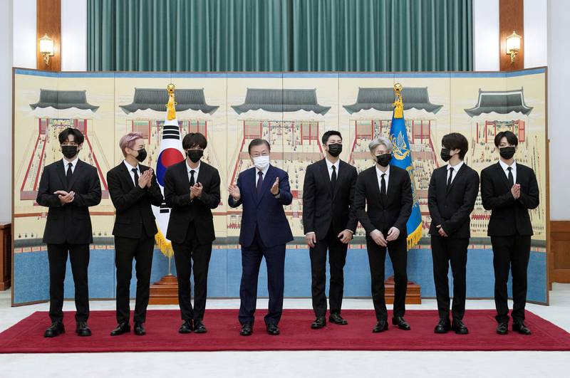 This picture taken on September 14, 2021 shows South Korean President Moon Jae-in (4th L) posing with members of K-pop sensation BTS as they receive diplomatic passports for a UN session as presidential special envoys at the presidential Blue House in Seoul.  (Photo by -  /  YONHAP  /  AFP)  /  - South Korea OUT  /  REPUBLIC OF KOREA OUT  NO ARCHIVES  RESTRICTED TO SUBSCRIPTION USE