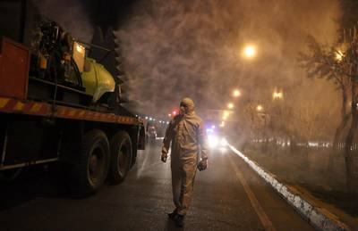 Iranian firefighters disinfects streets in an effort to halt the spread of coronavirus in Tehran, Iran.  EPA