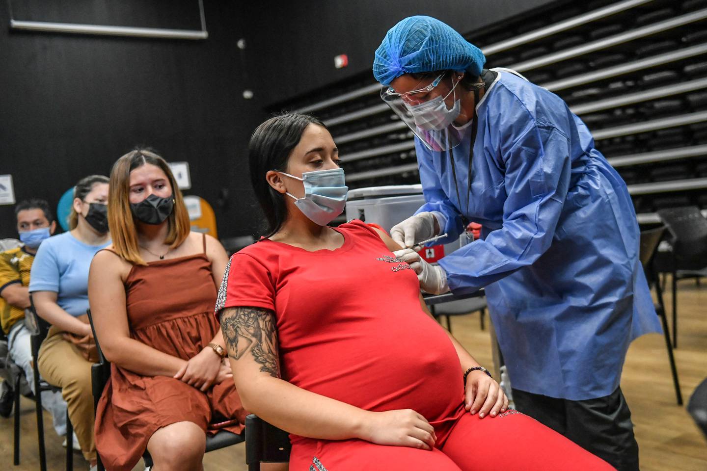 A pregnant woman is inoculated with Pfizer-BioNTech's Covid vaccine in Medellin, Colombia. AFP