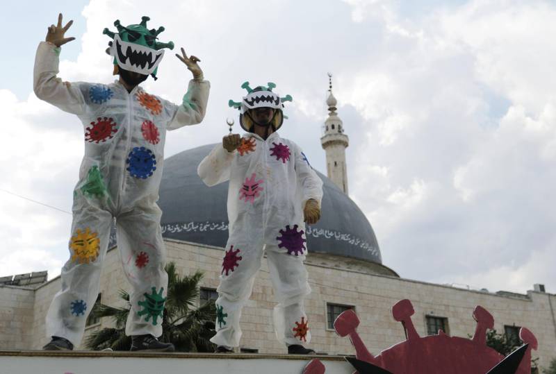 Volunteers dressed in coronavirus-themed costumes gesture as they stand on a vehicle during a campaign organised by the Violet Organisation, in an effort to spread awareness and encourage safety in the rebel-held Idlib city, Syria. Reuters