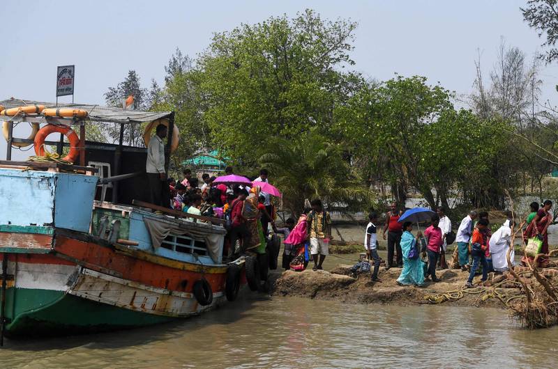 Indian voters arrive with a ferry boat to cast their vote in the Ghoramara island around 110 km south of Kolkata on May 19, 2019, during the 7th and final phase of India's general election. Voting in one of India's most acrimonious elections in decades entered its final day on May 19 as Hindu nationalist Prime Minister Narendra Modi scrambled to hang on to his overall majority. / AFP / Dibyangshu SARKAR
