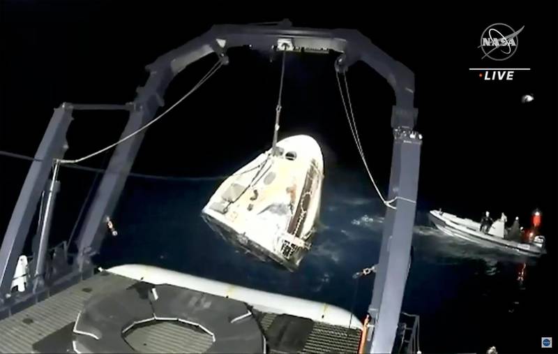 A support team winches up the SpaceX Dragon capsule from the Gulf of Mexico. AP Photo