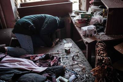 A Ukrainian woman collects her belongings after her apartment was damaged by a missile explosion in Kramatorsk, eastern Ukraine. AFP