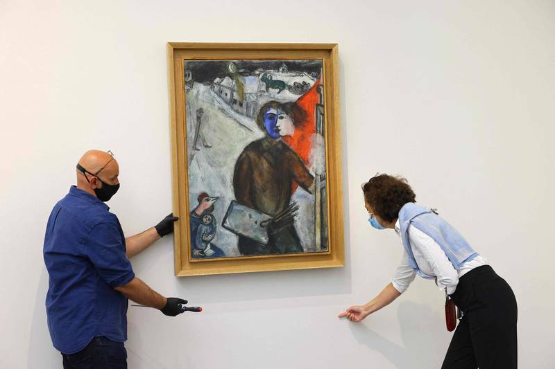 Workers hang 'Entre chien et loup' (Between Darkness and Light), by Marc Chagall at Louvre Abu Dhabi. AFP