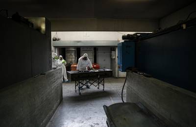 An employee readies the body of a woman who died from the new coronavirus for cremation at La Recoleta crematorium in Santiago, Chile. AP Photo