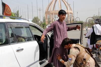 A security official checks people at a check point in Lashkar Gah, in Helmand province, Afghanistan.