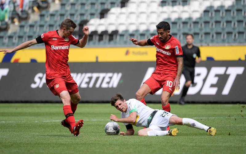 Bayer Leverkusen's Sven Bender and Kerem Demirbay in action with Borussia Moenchengladbach's Jonas Hofmann. Reuters