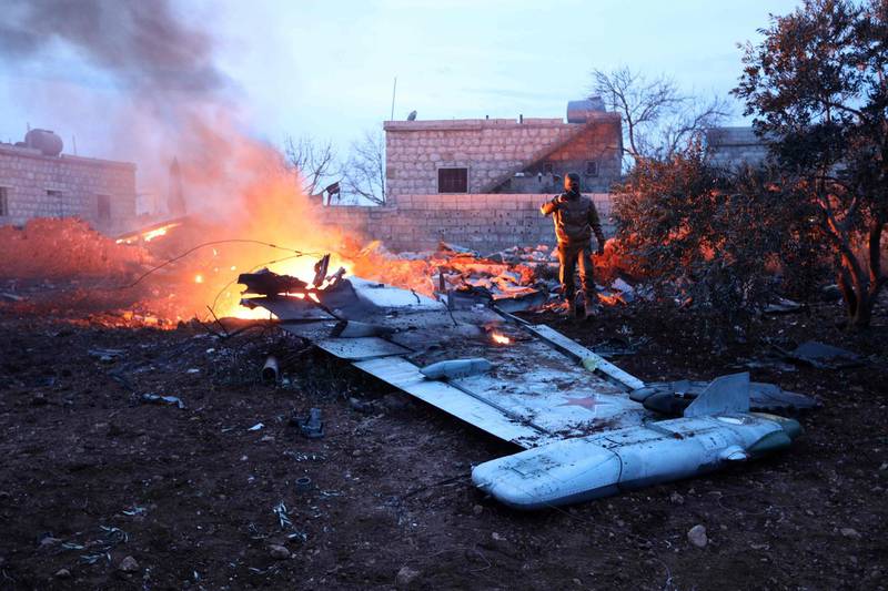 TOPSHOT - CORRECTION - A picture taken on February 3, 2018, shows a Rebel fighter taking a picture of a downed Sukhoi-25 fighter jet in Syria's northwest province of Idlib.
Rebel fighters shot down a Russian plane over Syria's northwest Idlib province and captured its pilot, the Syrian Observatory for Human Rights said. 
 / AFP PHOTO / OMAR HAJ KADOUR / “The erroneous mention[s] appearing in the metadata of this photo by OMAR HAJ KADOUR has been modified in AFP systems in the following manner: [in Syria's northwest province of Idlib.] instead of [near the Syrian city of Saraqib, southwest of Aleppo.]. Please immediately remove the erroneous mention[s] from all your online services and delete it (them) from your servers. If you have been authorized by AFP to distribute it (them) to third parties, please ensure that the same actions are carried out by them. Failure to promptly comply with these instructions will entail liability on your part for any continued or post notification usage. Therefore we thank you very much for all your attention and prompt action. We are sorry for the inconvenience this notification may cause and remain at your disposal for any further information you may require.”