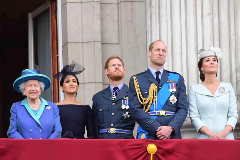 Queen Elizabeth, Meghan, Prince Harry, Prince William and Catherine watch the RAF 100th anniversary flypast from the balcony of Buckingham Palace in July 2018. Getty Images