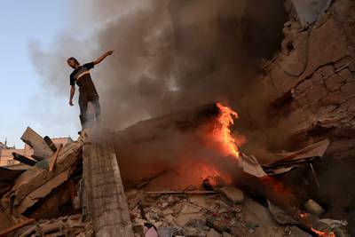 A Palestinian man stands on a collapsed building following a strike by the Israeli military on Khan Yunis in the southern Gaza Strip. AFP