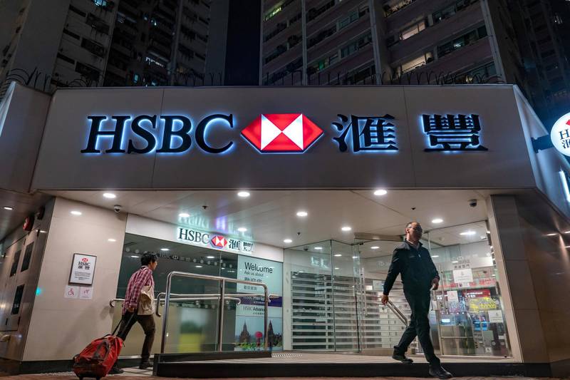 Customers exit and enter an HSBC Holdings Plc bank branch at night in Hong Kong, China, on Saturday, Feb. 16, 2019. HSBC is scheduled to release full year earnings results on Feb. 19. Photographer: Anthony Kwan/Bloomberg