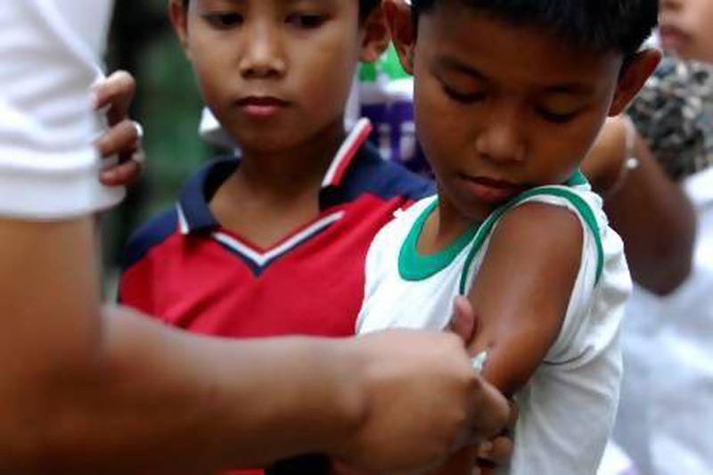 A Filipino nurse giving a boy his measles vaccine in a slum area in Tondo, Manila.