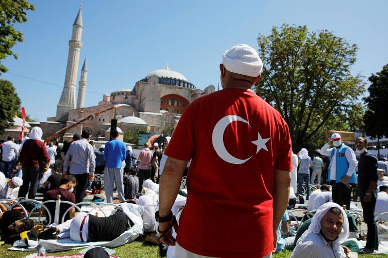 A man wearing a t-shirt with the Turkish flag stands as people wait for the beginning of Friday prayers outside Hagia Sophia Grand Mosque, after it was once again declared a mosque after 86 years, in Istanbul, Turkey.  Reuters