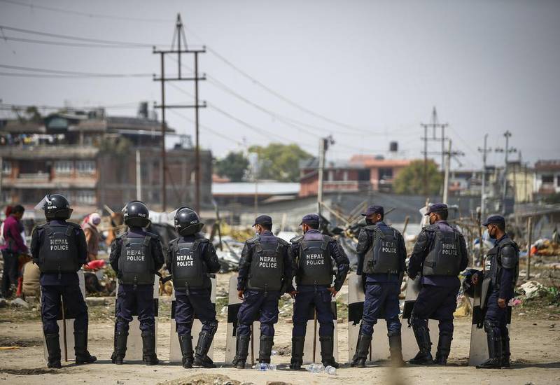 Nepalese police officers overlook an earthquake refugee camp in Kathmandu. The camp is to be demolished. Narendra Shrestha / EPA