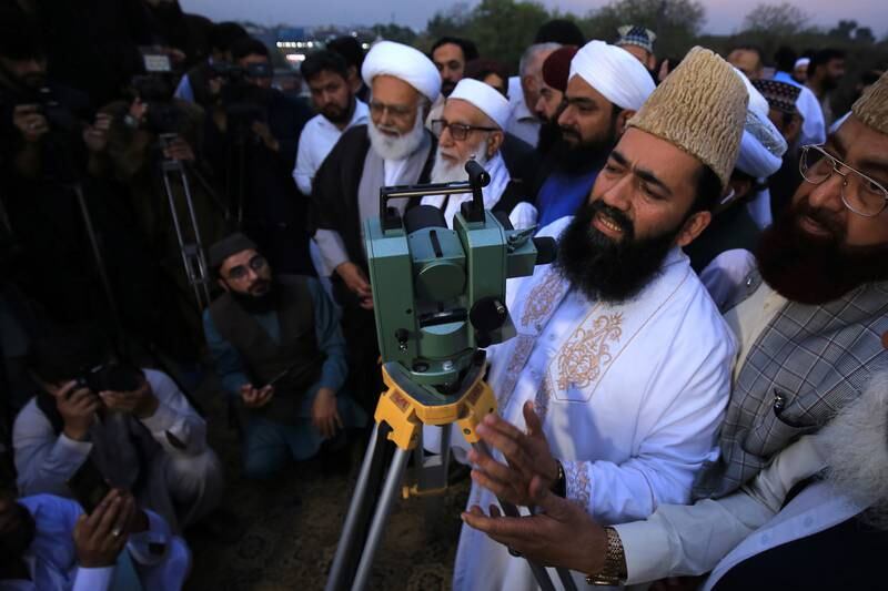 The chairman of a moon-sighting committee points a telescope at the skies in Peshawar, Pakistan. EPA