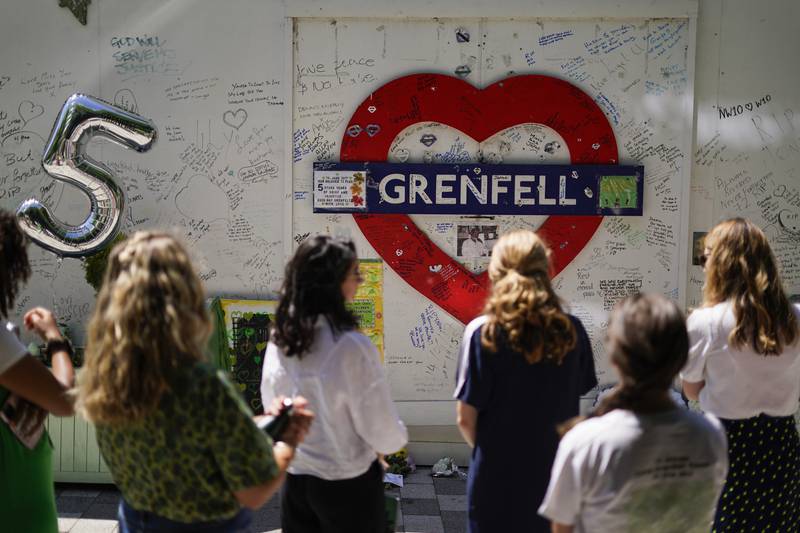 People observe the memorial near the Grenfell Tower site in London. AP Photo
