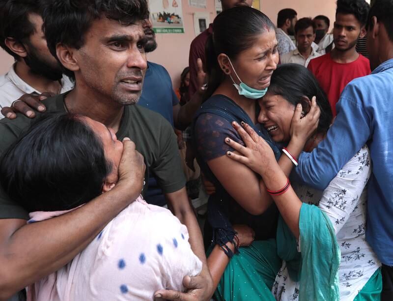 Relatives of one of the victims of a building fire in New Delhi mourn outside the morgue at Sanjay Gandhi Memorial Hospital on May 14, 2022. EPA