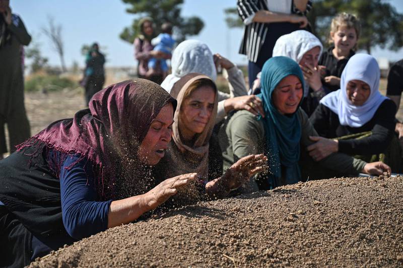People mourn in front of the grave of Halil Yagmur who was killed in a mortar attack a day earlier in Suruc near northern Syria border, during funeral ceremony in Suruc. Ten Turkish civilians were killed in cross-border shelling on Friday, while four of Turkey's soldiers died as Ankara pressed on with its offensive against Kurdish militants in Syria. Eight civilians were killed and 35 injured in one mortar strike in Nusaybin in Mardin province, according to the governor's office cited by local media. AFP
